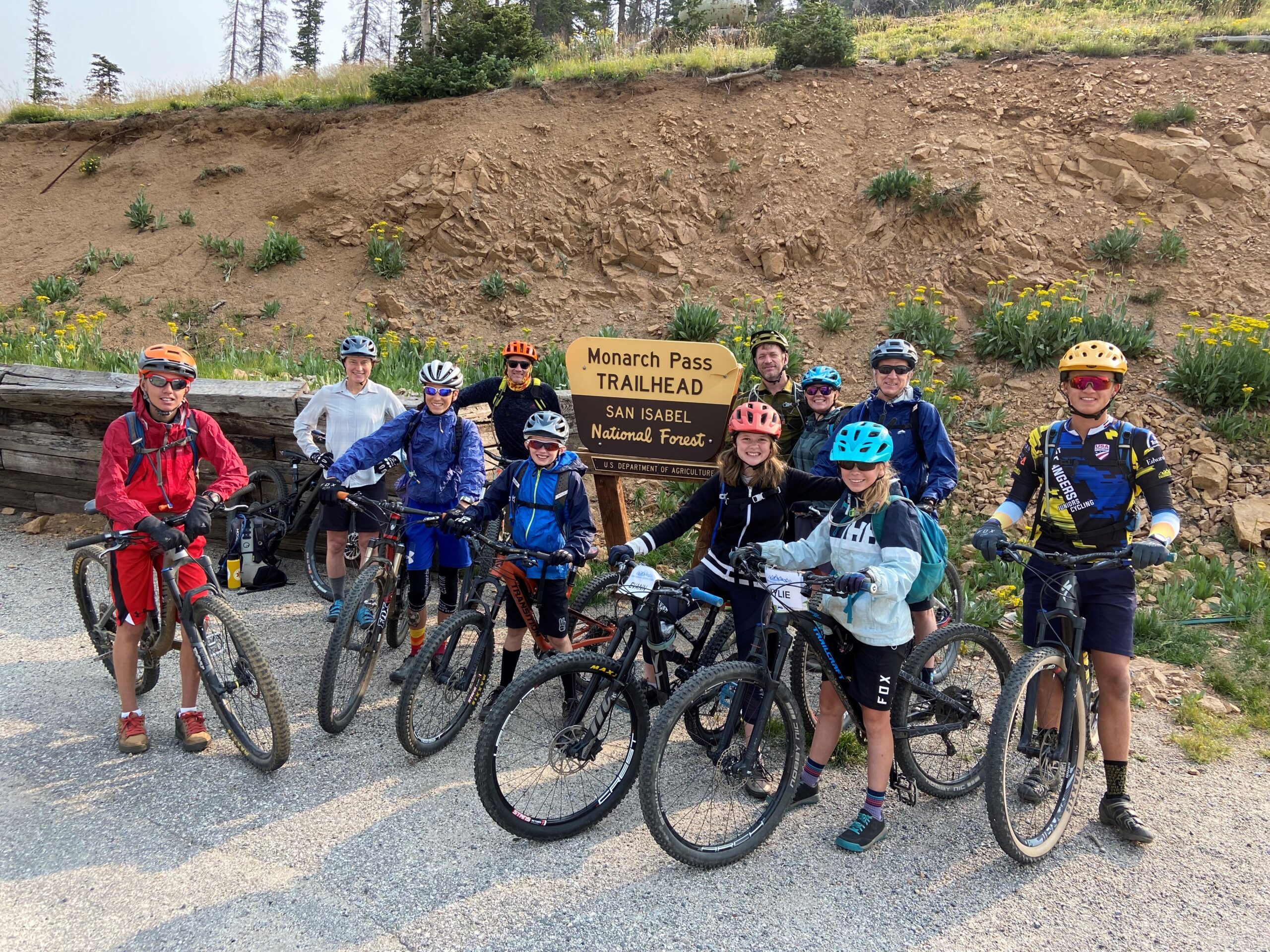 Group of Mountain Bikers standing by trailhead sign