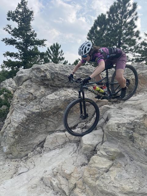 young athlete biking down a rock